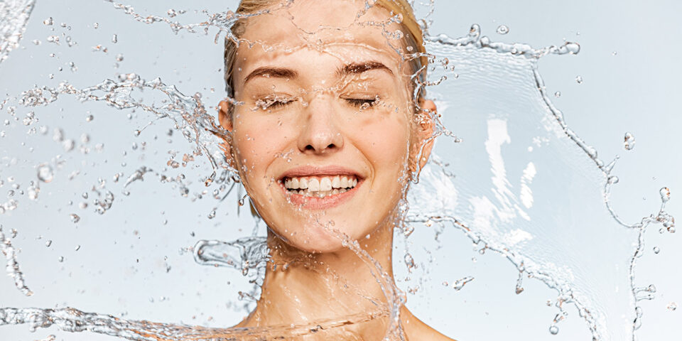 Photo of young woman with clean skin and splash of water. Port